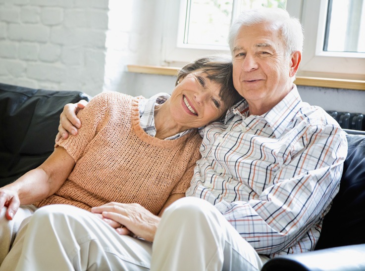 Elderly couple embracing on a couch